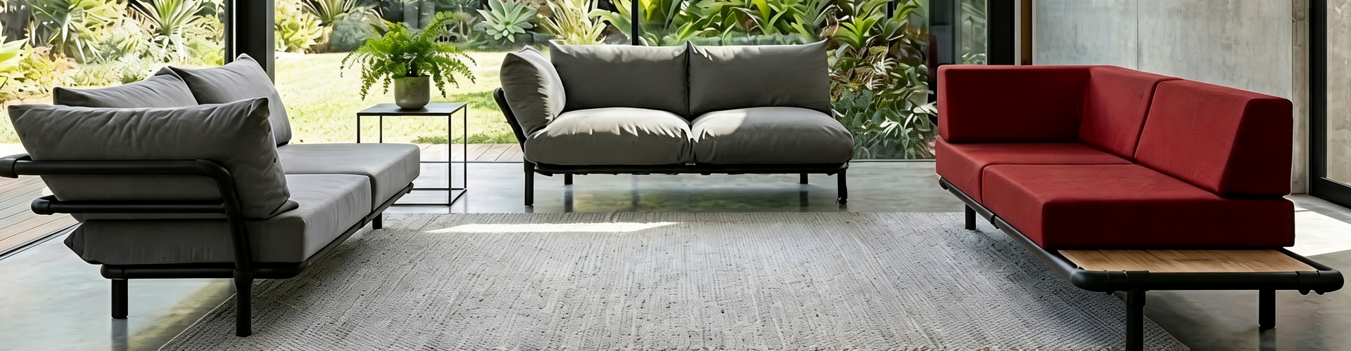 Een overzicht van drie industriële chaise longues in een lichte woonkamer: een grijze Mellow loungebank, een grijze Brion chaise longue en een rode Steady met houten vlonder-detail.